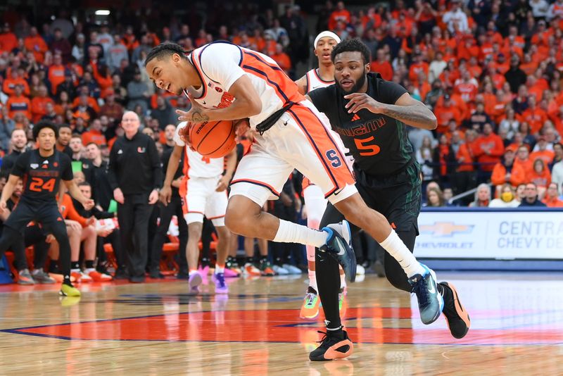 Jan 20, 2024; Syracuse, New York, USA; Syracuse Orange guard Judah Mintz (3) goes airborne as Miami (Fl) Hurricanes guard Wooga Poplar (5) defends during the first half at the JMA Wireless Dome. Mandatory Credit: Rich Barnes-USA TODAY Sports