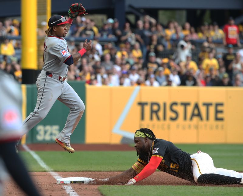 Apr 19, 2025; Pittsburgh, Pennsylvania, USA;  Pittsburgh Pirates designated hitter Oneil Cruz (right) advances to third base as Cleveland Guardians third baseman Jose Ramirez (11) takes a high throw during the sixth inning at PNC Park. Mandatory Credit: Charles LeClaire-Imagn Images