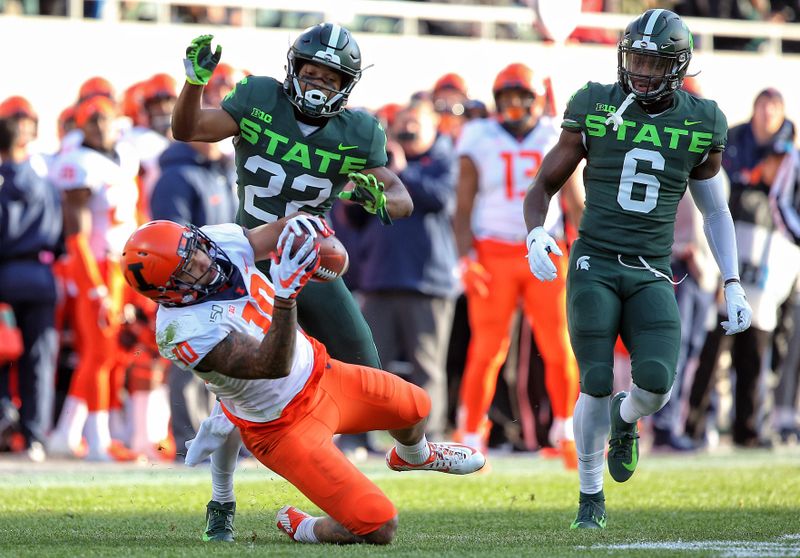 Nov 9, 2019; East Lansing, MI, USA; Illinois Fighting Illini tight end Justice Williams (10) makes a catch in front of Michigan State Spartans cornerback Josiah Scott (22) during the first quarter of a game at Spartan Stadium. Mandatory Credit: Mike Carter-USA TODAY Sports