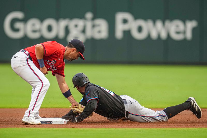 Aug 2, 2024; Cumberland, Georgia, USA; Miami Marlins shortstop Xavier Edwards (63) steals second base under the tag by Atlanta Braves second baseman Whit Merrifield (15) during the first inning at Truist Park. Mandatory Credit: Dale Zanine-USA TODAY Sports