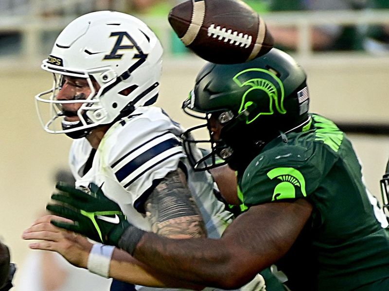 Sep 10, 2022; East Lansing, Michigan, USA;   Michigan State Spartans linebacker Jacoby Windmon (4) knocks the football from the grasp of Akron Zips quarterback Jeff Undercuffler Jr. (13) in the fourth quarter. Mandatory Credit: Dale Young-USA TODAY Sports