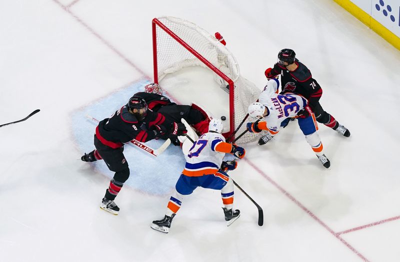 Apr 20, 2024; Raleigh, North Carolina, USA; New York Islanders center Kyle MacLean (32) scores a goal past Carolina Hurricanes goaltender Frederik Andersen (31) during the first period in game one of the first round of the 2024 Stanley Cup Playoffs at PNC Arena. Mandatory Credit: James Guillory-USA TODAY Sports