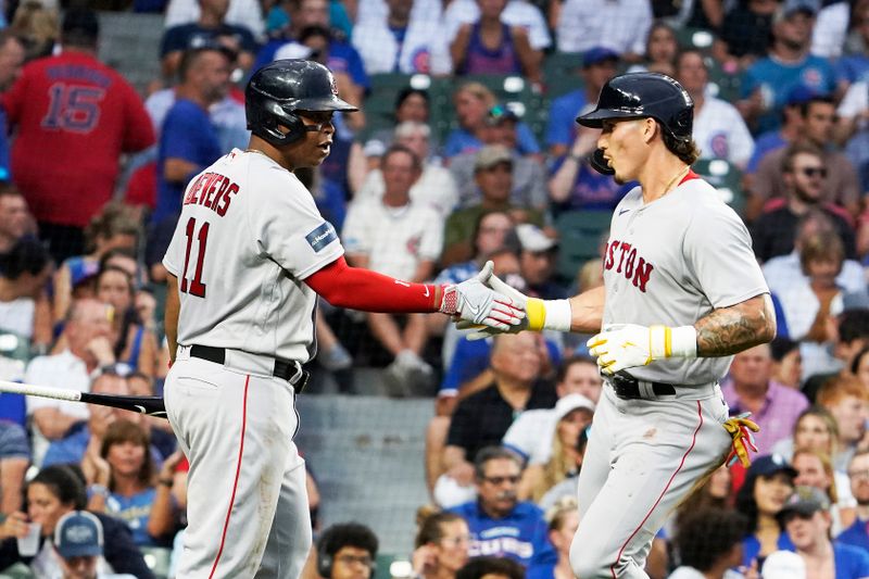 Jul 14, 2023; Chicago, Illinois, USA; Boston Red Sox left fielder Jarren Duran (16) is greeted by third baseman Rafael Devers (11) after scoring against the Chicago Cubs during the third inning at Wrigley Field. Mandatory Credit: David Banks-USA TODAY Sports