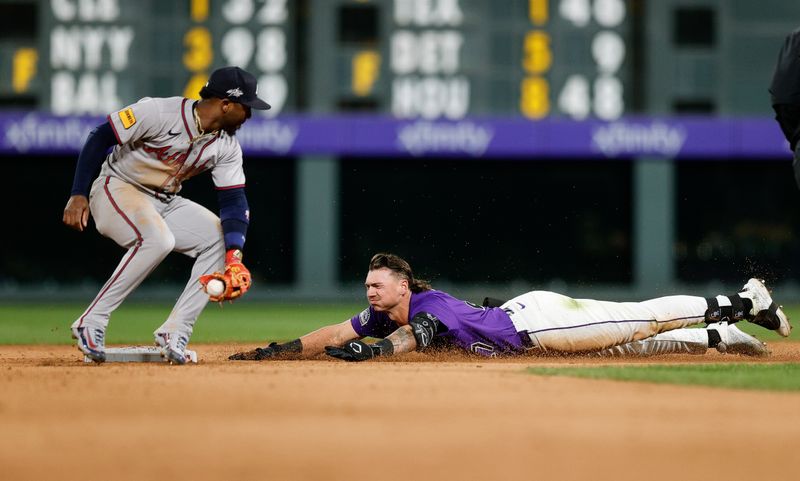 Apr 28, 2025; Denver, Colorado, USA; Colorado Rockies left fielder Jordan Beck (27) slides into second on a double against Atlanta Braves second baseman Ozzie Albies (1) in the eighth inning at Coors Field. Mandatory Credit: Isaiah J. Downing-Imagn Images
