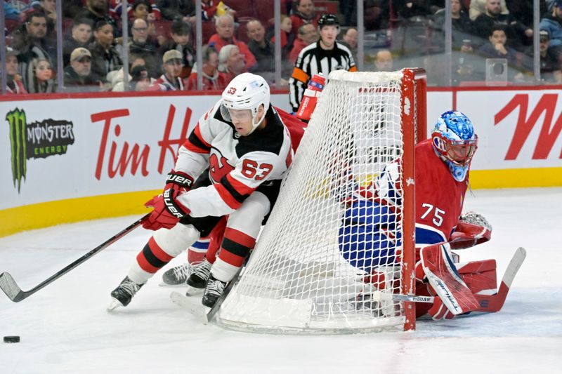 Jan 25, 2025; Montreal, Quebec, CAN; New Jersey Devils forward Jesper Bratt (63) plays the puck behind the net of Montreal Canadiens goalie Jakub Dobes (75) during the first period at the Bell Centre. Mandatory Credit: Eric Bolte-Imagn Images