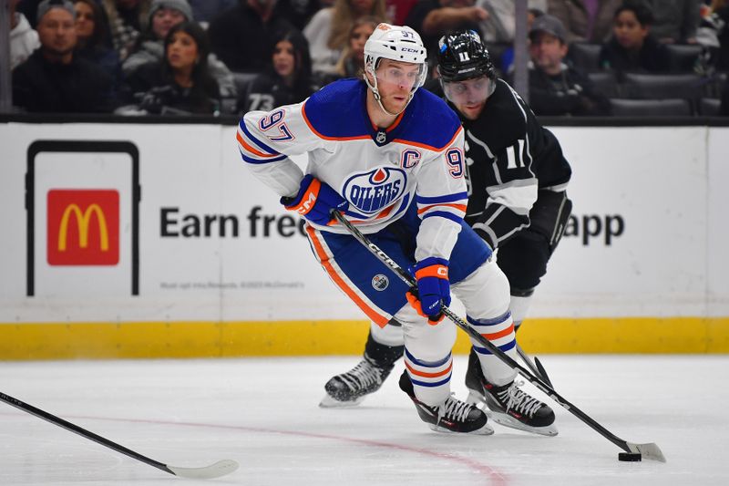 Dec 30, 2023; Los Angeles, California, USA; Edmonton Oilers center Connor McDavid (97) moves the puck ahead of Los Angeles Kings center Anze Kopitar (11) during the first period at Crypto.com Arena. Mandatory Credit: Gary A. Vasquez-USA TODAY Sports