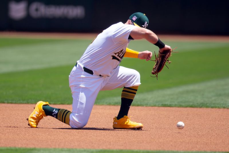 Jul 20, 2024; Oakland, California, USA; Oakland Athletics first baseman Seth Brown (15) momentarily loses his grip on the ball before recovering and putting out Los Angeles Angels third baseman Anthony Rendon at first base during the first inning at Oakland-Alameda County Coliseum. Mandatory Credit: D. Ross Cameron-USA TODAY Sports