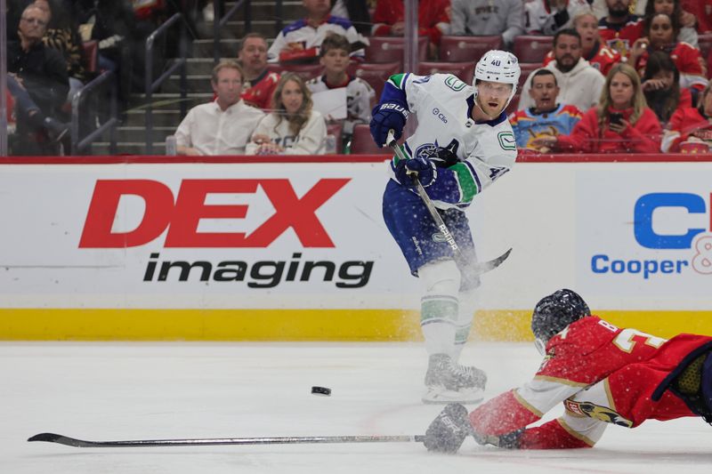 Oct 17, 2024; Sunrise, Florida, USA; Vancouver Canucks center Elias Pettersson (40) passes the puck as Florida Panthers right wing Patrick Giles (36) defends during the second period at Amerant Bank Arena. Mandatory Credit: Sam Navarro-Imagn Images