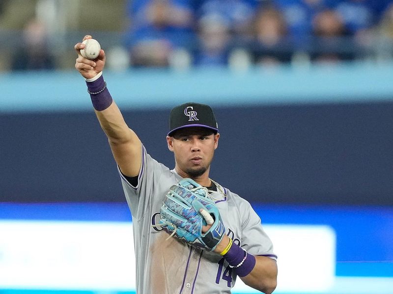 Apr 14, 2024; Toronto, Ontario, CAN; Colorado Rockies shortstop Ezequiel Tovar (14) holds onto the ball hit by Toronto Blue Jays third baseman Ernie Clement (not pictured) during the eighth inning at Rogers Centre. Mandatory Credit: John E. Sokolowski-USA TODAY Sports