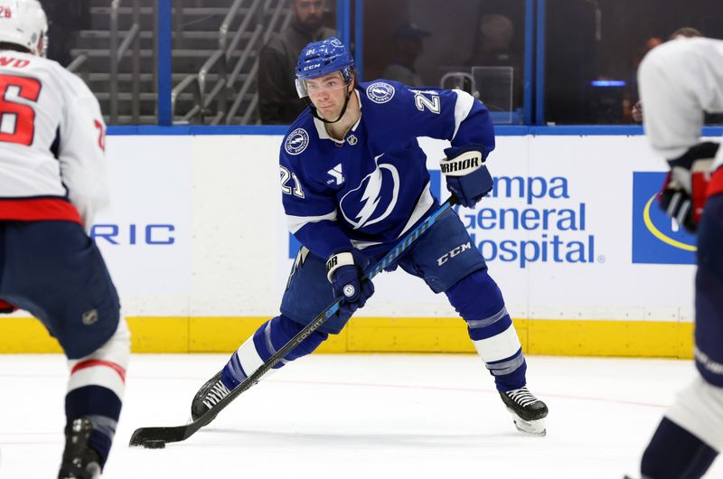 Nov 27, 2024; Tampa, Florida, USA;Tampa Bay Lightning center Brayden Point (21) passes the puck against the Washington Capitals during the first period at Amalie Arena. Mandatory Credit: Kim Klement Neitzel-Imagn Images