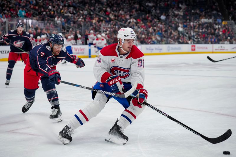 Nov 29, 2023; Columbus, Ohio, USA;  Montreal Canadiens center Sean Monahan (91) skates with the puck against Columbus Blue Jackets center Sean Kuraly (7) in the third period at Nationwide Arena. Mandatory Credit: Aaron Doster-USA TODAY Sports