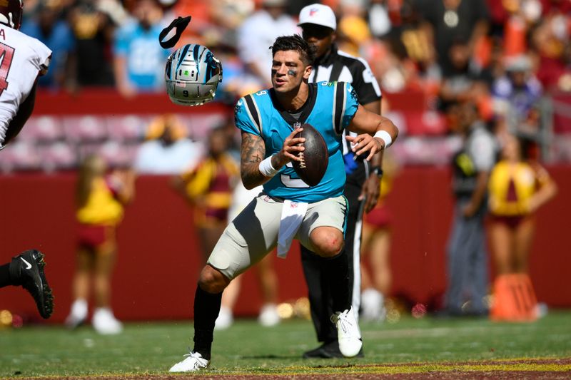 Carolina Panthers quarterback Matt Corral loses his helmet after it was pulled off by Washington Commanders defensive end Shaka Toney during the second half of a preseason NFL football game, Saturday, Aug. 13, 2022, in Landover, Md. (AP Photo/Nick Wass)