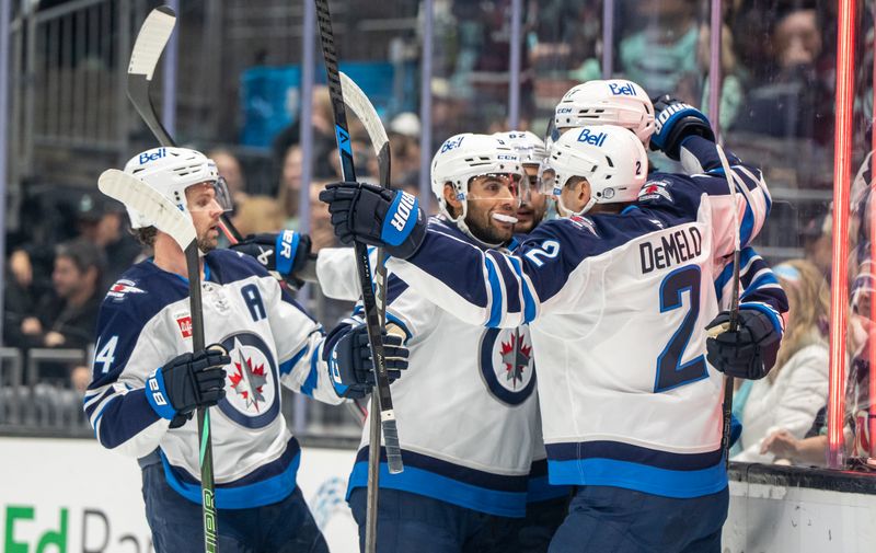 Nov 13, 2025; Seattle, Washington, USA; Winnipeg Jets forward Gustav Nyquist (14), left, forward Alex Iafallo (9) and defenseman Dylan DeMelo (2) celebrate a goal during the first period against the Seattle Kraken at Climate Pledge Arena. Mandatory Credit: Stephen Brashear-Imagn Images