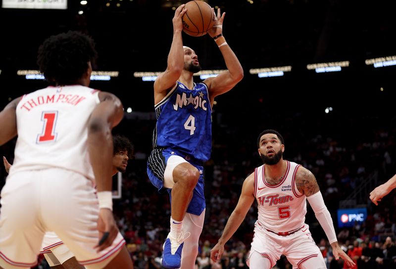 HOUSTON, TEXAS - APRIL 09: Jalen Suggs #4 of the Orlando Magic goes up for a shot while defended by Fred VanVleet #5 of the Houston Rockets in the first half at Toyota Center on April 09, 2024 in Houston, Texas.  NOTE TO USER: User expressly acknowledges and agrees that, by downloading and or using this photograph, User is consenting to the terms and conditions of the Getty Images License Agreement. (Photo by Tim Warner/Getty Images)