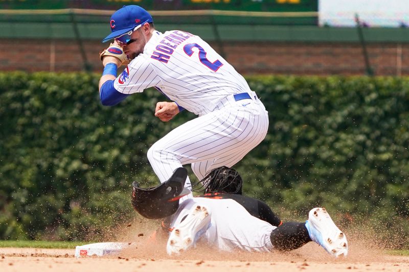 Jun 18, 2023; Chicago, Illinois, USA; Chicago Cubs second baseman Nico Hoerner (2) tags out Baltimore Orioles shortstop Jorge Mateo (3) at second base during the sixth inning at Wrigley Field. Mandatory Credit: David Banks-USA TODAY Sports