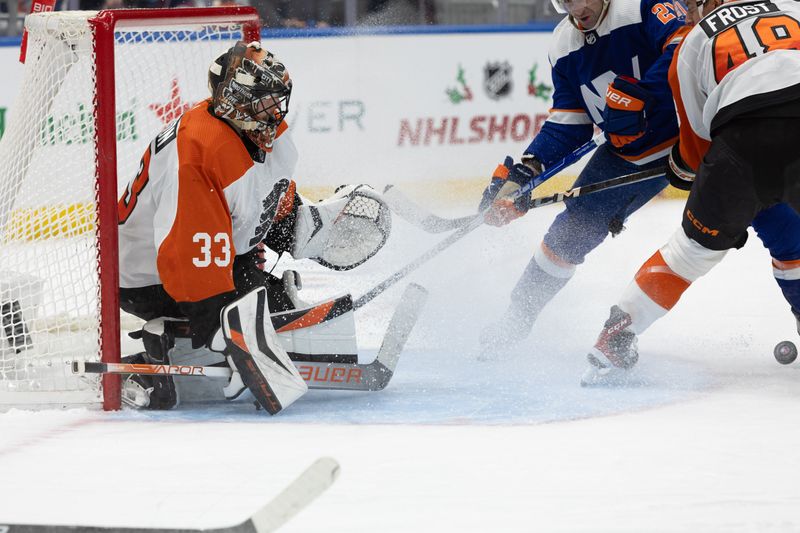 Nov 25, 2023; Elmont, New York, USA; Philadelphia Flyers goaltender Samuel Ersson (33) tracks the puck in front of the net against the New York Islanders during the second period at UBS Arena. Mandatory Credit: Thomas Salus-USA TODAY Sports