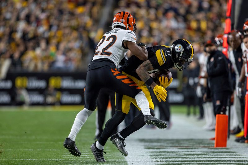 Pittsburgh Steelers wide receiver Allen Robinson II (11) catches a pass along the sideline in front of Cincinnati Bengals cornerback Chidobe Awuzie (22) during an NFL football game, Saturday, Dec. 23, 2023, in Pittsburgh. (AP Photo/Matt Durisko)