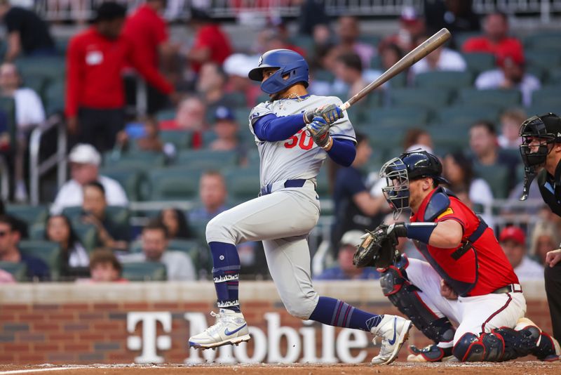 May 2, 2025; Atlanta, Georgia, USA; Los Angeles Dodgers shortstop Mookie Betts (50) hits a single against the Atlanta Braves in the fourth inning at Truist Park. Mandatory Credit: Brett Davis-Imagn Images
