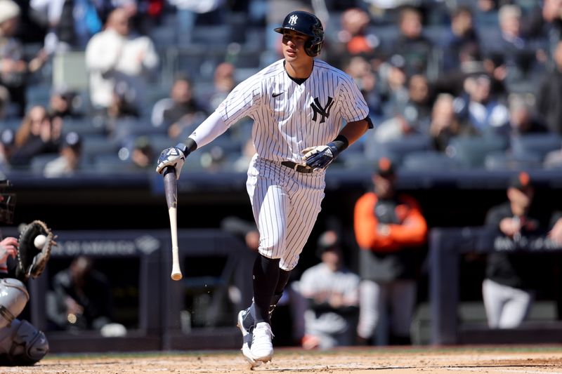 Mar 30, 2023; Bronx, New York, USA; New York Yankees shortstop Anthony Volpe (11) tosses his bat after drawing a walk in his first major league at bat during the third inning against the San Francisco Giants at Yankee Stadium. Mandatory Credit: Brad Penner-USA TODAY Sports