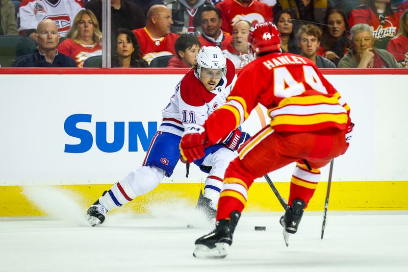 Oct 22, 2025; Calgary, Alberta, CAN; Montreal Canadiens right wing Brendan Gallagher (11) controls the puck against Calgary Flames defenseman Joel Hanley (44) during the first period at Scotiabank Saddledome. Mandatory Credit: Sergei Belski-Imagn Images