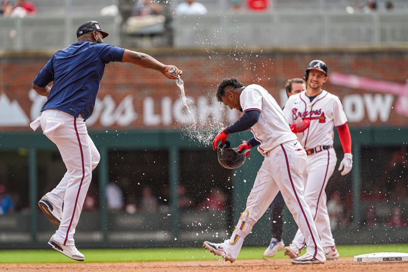 Jul 20, 2024; Cumberland, GA, USA; Atlanta Braves second baseman Ozzie Albies (1) gets hit with water by Marcell Ozuna (blue shirt)  after hitting a game winning sacrifice fly ball against the St. Louis Cardinals during the tenth inning at Truist Park. Mandatory Credit: Dale Zanine-USA TODAY Sports