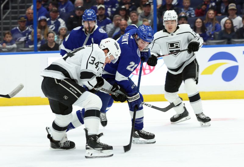 Jan 9, 2024; Tampa, Florida, USA; Tampa Bay Lightning center Brayden Point (21) skates with the puck as Los Angeles Kings right wing Arthur Kaliyev (34) defends  during the first period at Amalie Arena. Mandatory Credit: Kim Klement Neitzel-USA TODAY Sports