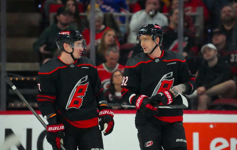 Mar 12, 2024; Raleigh, North Carolina, USA; Carolina Hurricanes defenseman Dmitry Orlov (7) and center Evgeny Kuznetsov (92) talk against the New York Rangers during the first period at PNC Arena. Mandatory Credit: James Guillory-USA TODAY Sports