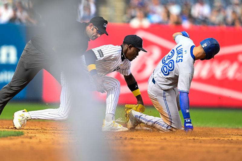 Sep 7, 2025; Bronx, New York, USA; New York Yankees second baseman Jazz Chisholm Jr. (13) tags out Toronto Blue Jays left fielder Nathan Lukes (38) during the ninth inning at Yankee Stadium. Mandatory Credit: Mark Smith-Imagn Images