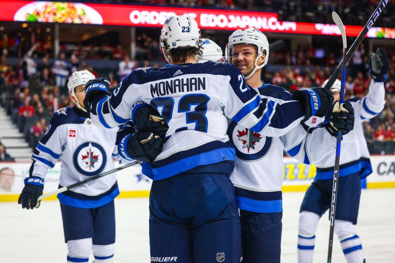 Feb 19, 2024; Calgary, Alberta, CAN; Winnipeg Jets center Sean Monahan (23) celebrates his goal with teammates against the Calgary Flames during the first period at Scotiabank Saddledome. Mandatory Credit: Sergei Belski-USA TODAY Sports