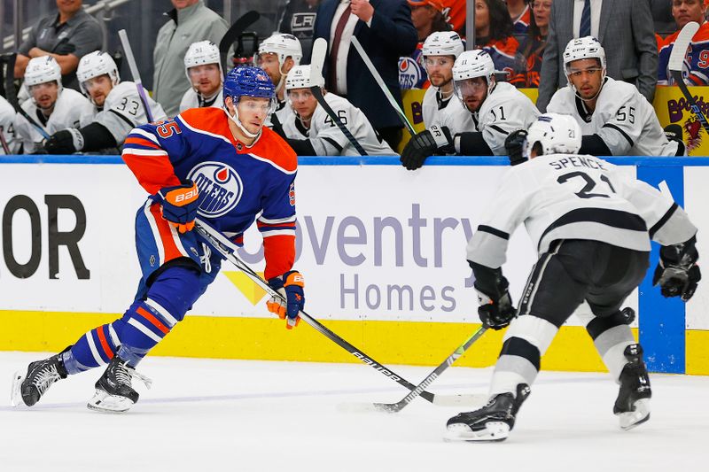 May 1, 2024; Edmonton, Alberta, CAN; Edmonton Oilers forward Dylan Holloway (55) chips the puck past Los Angeles Kings defensemen Jordan Spence (21) during the third period in game five of the first round of the 2024 Stanley Cup Playoffs at Rogers Place. Mandatory Credit: Perry Nelson-USA TODAY Sports