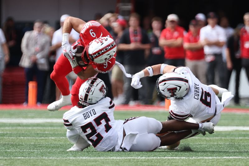 Sep 20, 2025; Salt Lake City, Utah, USA; Utah Utes wide receiver Ryan Davis (9) is tackled by Texas Tech Red Raiders defensive back Amier Boyd (27) and linebacker John Curry (6) during the first quarter at Rice-Eccles Stadium. Mandatory Credit: Rob Gray-Imagn Images