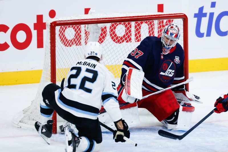Oct 26, 2025; Winnipeg, Manitoba, CAN; Winnipeg Jets goalie Connor Hellebuyck (37) stops Utah Mammoth forward forward Jack McBain (22) during the second period at Canada Life Centre. Mandatory Credit: Terrence Lee-Imagn Images