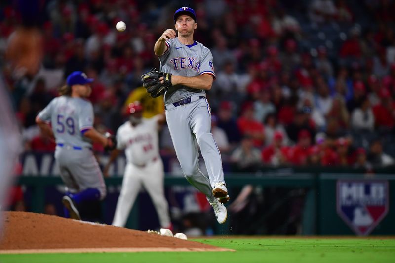 Sep 27, 2024; Anaheim, California, USA; Texas Rangers third baseman Matt Duffy (9) throws to first for the out against Los Angeles Angels second baseman Michael Stefanic (38) during the seventh inning at Angel Stadium. Mandatory Credit: Gary A. Vasquez-Imagn Images