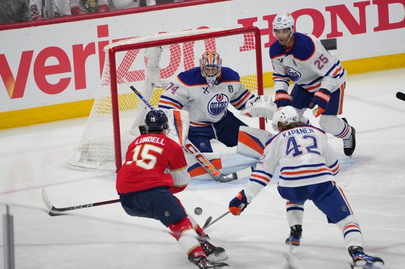 Jun 9, 2025; Sunrise, Florida, USA; Edmonton Oilers goaltender Stuart Skinner (74) and right wing Kasperi Kapanen (42) defend against Florida Panthers forward Anton Lundell (15) during the first period in game three of the 2025 Stanley Cup Final at Amerant Bank Arena. Mandatory Credit: Jim Rassol-Imagn Images