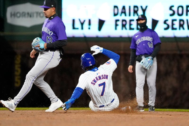 Apr 3, 2024; Chicago, Illinois, USA; Chicago Cubs shortstop Dansby Swanson (7) steals second base as Colorado Rockies second baseman Alan Trejo (13) stands nearby during the second inning at Wrigley Field. Mandatory Credit: David Banks-USA TODAY Sports