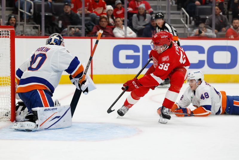 Dec 16, 2025; Detroit, Michigan, USA;  Detroit Red Wings center Emmitt Finnie (58) skates with the puck defended by New York Islanders defenseman Matthew Schaefer (48) in the second period at Little Caesars Arena. Mandatory Credit: Rick Osentoski-Imagn Images