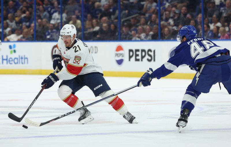 Oct 5, 2023; Tampa, Florida, USA;Florida Panthers center Nick Cousins (21) shoots as Tampa Bay Lightning defenseman Nick Perbix (48) defends during the first period at Amalie Arena. Mandatory Credit: Kim Klement Neitzel-USA TODAY Sports