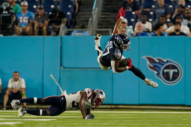 New England Patriots cornerback Quandre Mosely trips up Tennessee Titans tight end Alize Mack (87) on a pass reception in the second half of an NFL preseason football game Friday, Aug. 25, 2023, in Nashville, Tenn. (AP Photo/George Walker IV)