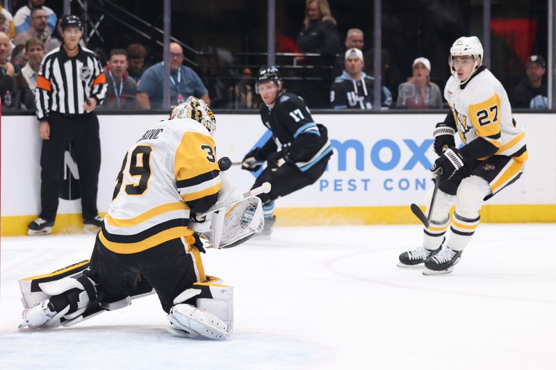 Jan 29, 2025; Salt Lake City, Utah, USA; Pittsburgh Penguins goaltender Alex Nedeljkovic (39) blocks a shot by the Utah Hockey Club during the second period at Delta Center. Mandatory Credit: Rob Gray-Imagn Images