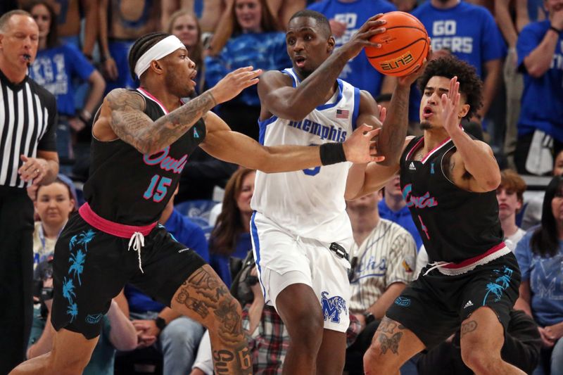 Feb 25, 2024; Memphis, Tennessee, USA; Memphis Tigers forward David Jones (8) handles the ball as Florida Atlantic Owls guard Alijah Martin (15) and Florida Atlantic Owls guard Bryan Greenlee (4) defend during the second half at FedExForum. Mandatory Credit: Petre Thomas-USA TODAY Sports