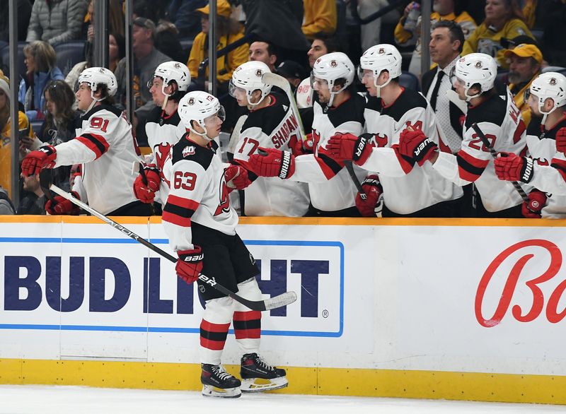 Jan 26, 2023; Nashville, Tennessee, USA; New Jersey Devils left wing Jesper Bratt (63) is congratulated by teammates after a goal during the first period against the Nashville Predators at Bridgestone Arena. Mandatory Credit: Christopher Hanewinckel-USA TODAY Sports