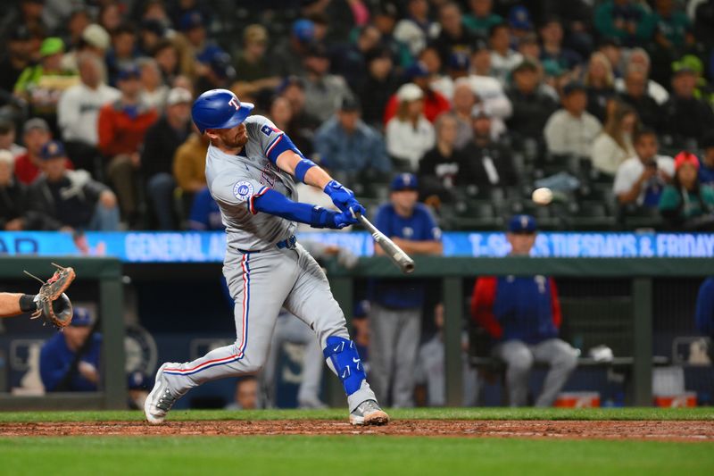 Sep 14, 2024; Seattle, Washington, USA; Texas Rangers catcher Carson Kelly (18) hits a single against the Seattle Mariners during the fifth inning at T-Mobile Park. Mandatory Credit: Steven Bisig-Imagn Images