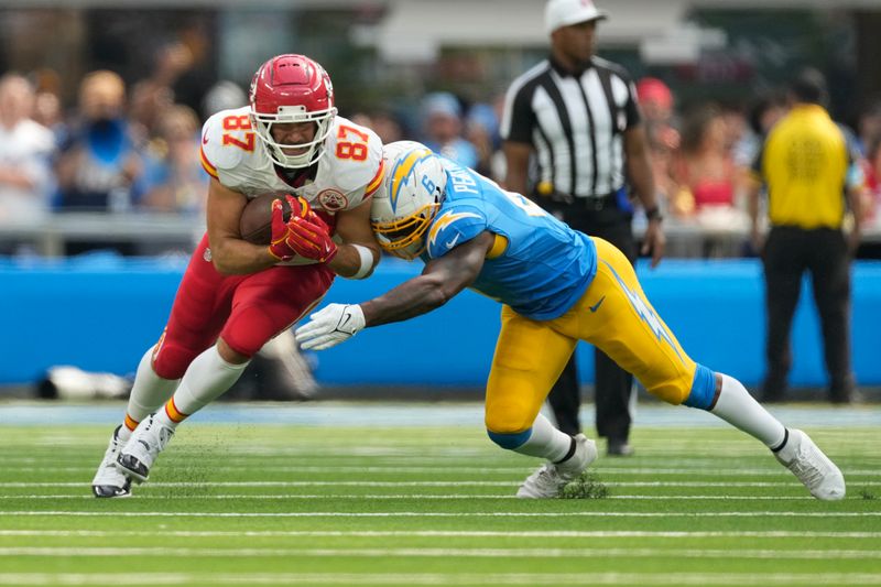 Kansas City Chiefs tight end Travis Kelce (87) is stopped by Los Angeles Chargers linebacker Denzel Perryman (6) during the first half of an NFL football game Sunday, Sept. 29, 2024, in Inglewood, Calif. (AP Photo/Ashley Landis)