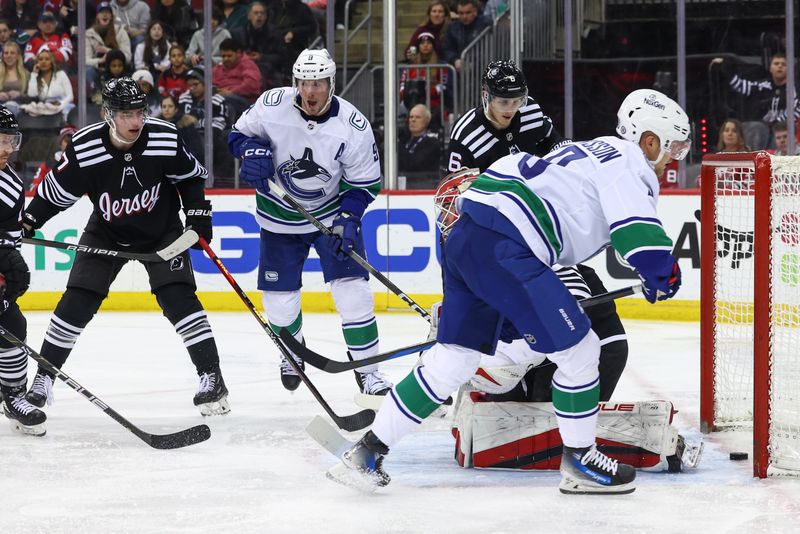 Jan 6, 2024; Newark, New Jersey, USA; Vancouver Canucks center Elias Pettersson (40) scores a goal on New Jersey Devils goaltender Nico Daws (50) during the third period at Prudential Center. Mandatory Credit: Ed Mulholland-USA TODAY Sports