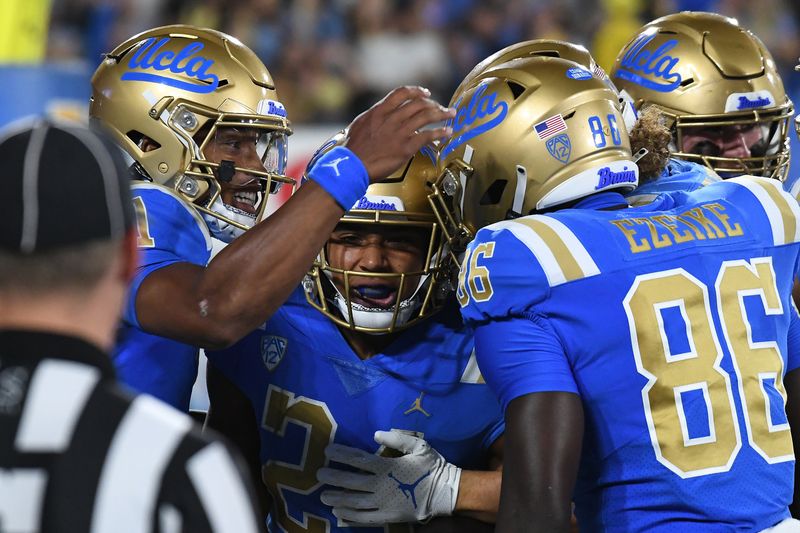 Sep 18, 2021; Pasadena, California, USA; UCLA Bruins running back Zach Charbonnet (24) celebrates with quarterback Dorian Thompson-Robinson (1) and teammates after running for a touchdown against the Fresno State Bulldogs in the first quarter at Rose Bowl. Mandatory Credit: Richard Mackson-USA TODAY Sports