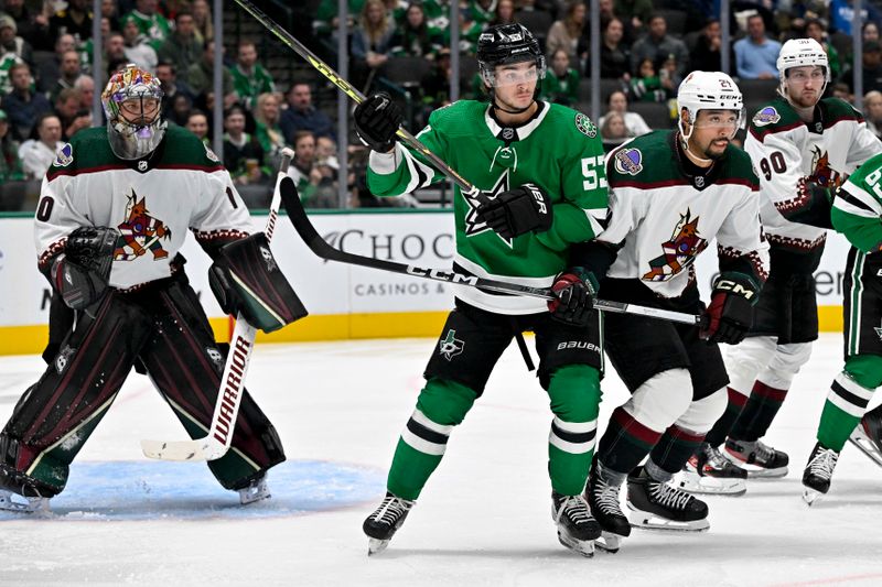 Nov 14, 2023; Dallas, Texas, USA; Dallas Stars center Wyatt Johnston (53) and Arizona Coyotes defenseman Matt Dumba (24) look for the puck in front of goaltender Karel Vejmelka (70) during the second period at the American Airlines Center. Mandatory Credit: Jerome Miron-USA TODAY Sports