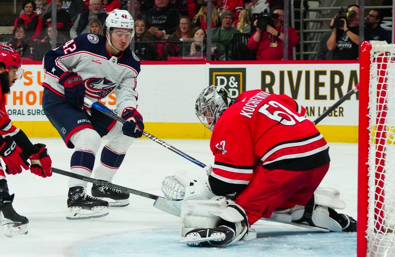 Nov 26, 2023; Raleigh, North Carolina, USA;  Carolina Hurricanes goaltender Pyotr Kochetkov (52) stops the scoring attempt by Columbus Blue Jackets center Alexandre Texier (42) during the second period at PNC Arena. Mandatory Credit: James Guillory-USA TODAY Sports