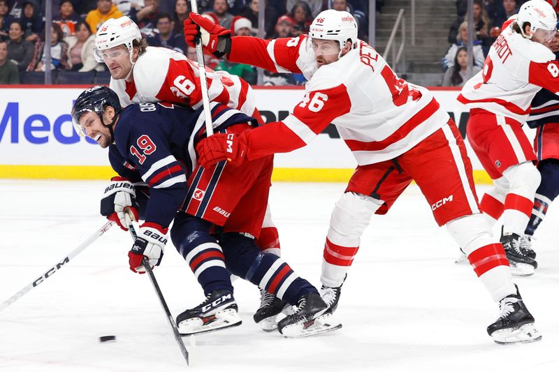 Dec 20, 2023; Winnipeg, Manitoba, CAN; Winnipeg Jets center David Gustafsson (19) and Detroit Red Wings defenseman Jeff Petry (46) eye an incoming puck in the second period at Canada Life Centre. Mandatory Credit: James Carey Lauder-USA TODAY Sports