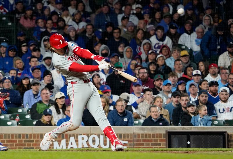 Apr 27, 2025; Chicago, Illinois, USA; Philadelphia Phillies third base Alec Bohm (28) hits the go ahead sacrifice fly against the Chicago Cubs during the tenth inning at Wrigley Field. Mandatory Credit: David Banks-Imagn Images