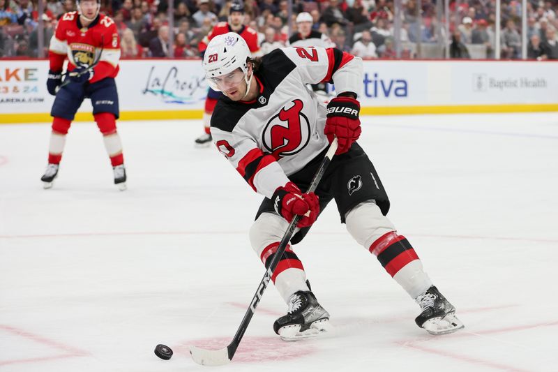 Jan 13, 2024; Sunrise, Florida, USA; New Jersey Devils center Michael McLeod (20) moves the puck against the Florida Panthers during the first period at Amerant Bank Arena. Mandatory Credit: Sam Navarro-USA TODAY Sports